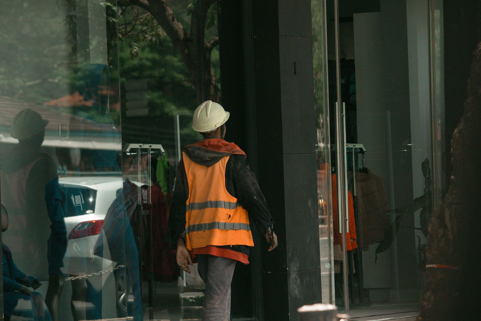 Worker in reflective vest behind glass storefront